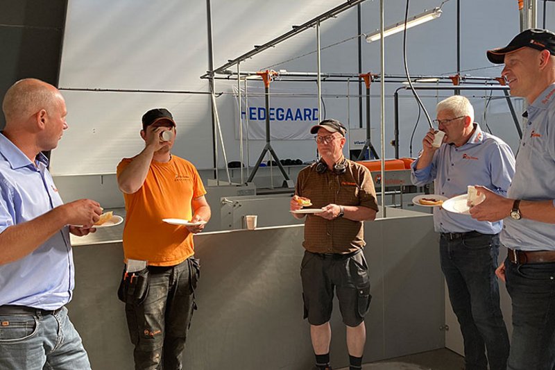 Пятеро мужчин общаются в корпусе за едой и напитками.