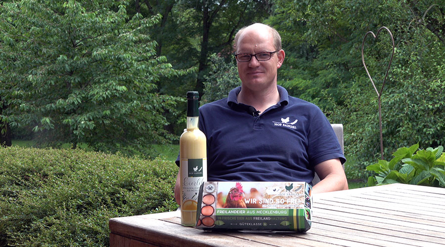 Farmer Sven Sangel with a bottle of egg liqueur and an egg box